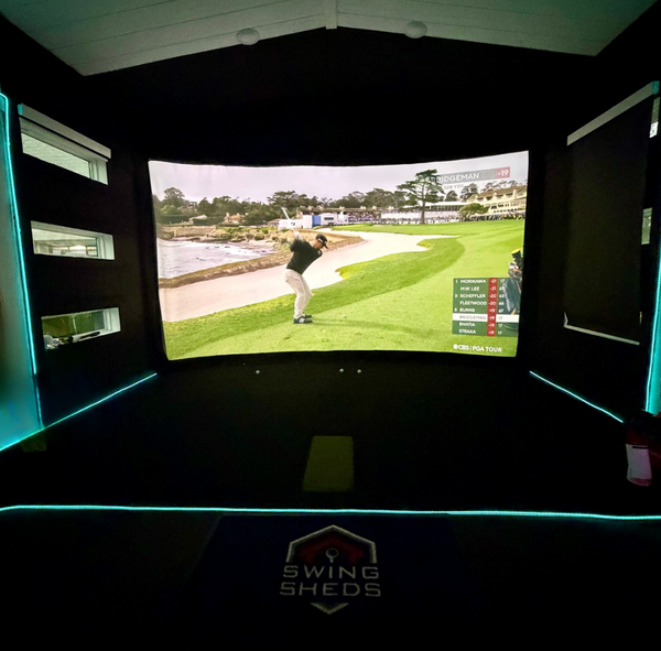 Golf simulator setup with screen displaying a golf course, branded 'Swing Sheds'.