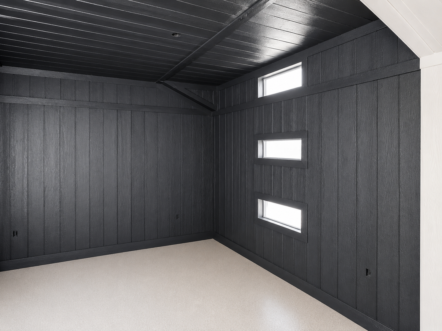 Modern room with dark paneled walls and ceiling, featuring three rectangular windows.