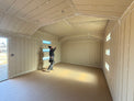 Person inside a newly built shed with beige walls and ceiling.