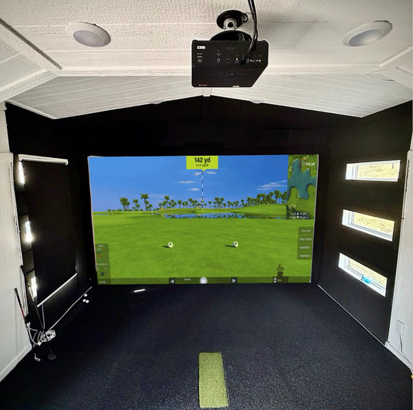Indoor golf simulator setup with screen displaying a golf course.
