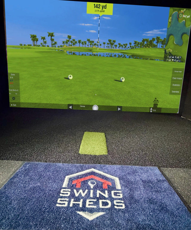 Golf simulator setup with screen displaying a golf course and 'Swing Sheds' logo on the floor.